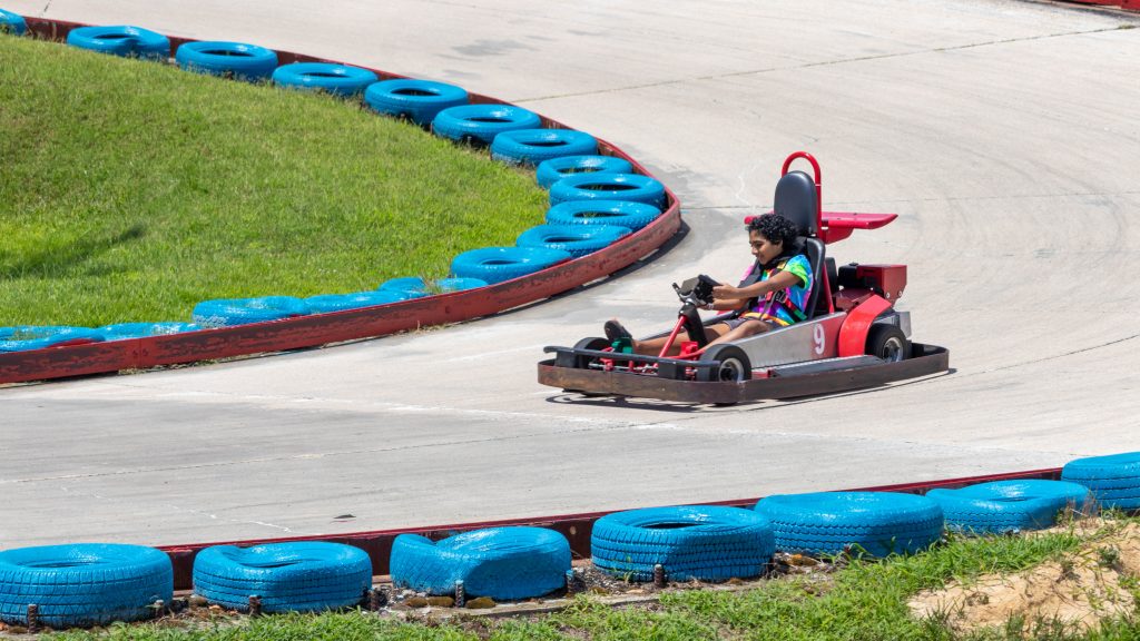 Red go cart on track with blue barriers