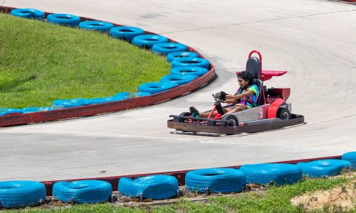 Red go cart on track with blue barriers
