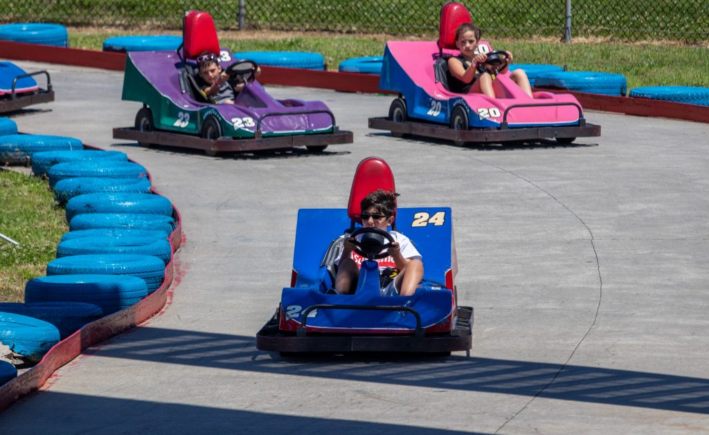 Kids on colorful go carts racing on track