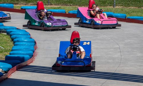 Kids on colorful go carts racing on track